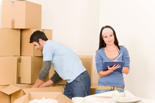 Professional movers carrying furniture through a Hackney flat entrance
